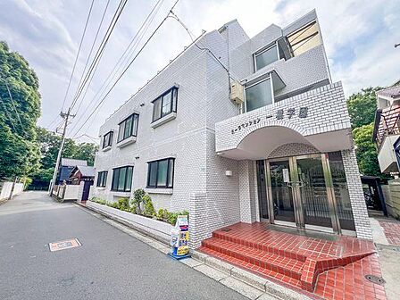 青空に美しく映えるホワイトタイル貼りのスタイリッシュな外観。前面道路はすっきりと見通しが良く、小さなお子様やベビーカーでの移動も安心の、落ち着いた住環境です。