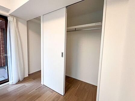 「洋室5.6帖クローゼット」 ハンガーパイプと上部棚を備えた収納空間。お部屋を広く保てます。