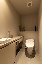 レストルームも水回りの統一感がある空間に仕上げました。タンクレストイレやスティックリモコン、手洗いカウンターなどを設置し、清潔感がありスマートな雰囲気を醸し出します。