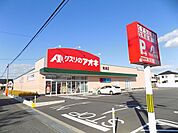 銀行「クスリのアオキまで940m」