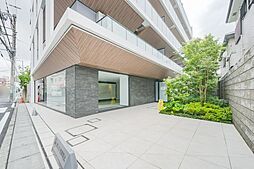 建築素材の質感に植栽の緑が彩りを添えるエントランス。人工的なデザインと自然のアクセントが調和し、印象的な空間を演出します。