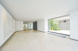 大きなガラス面が内と外をゆるやかにつなぎ、伸びやかな広がりを演出。外の景色と室内の落ち着きが対照的な表情を生み出す、印象的なエントランス空間です。