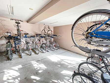 大切な自転車を雨風から守る、安心の屋内(屋根付き)駐輪スペース。ラック式で整理されており、出し入れもスムーズです。