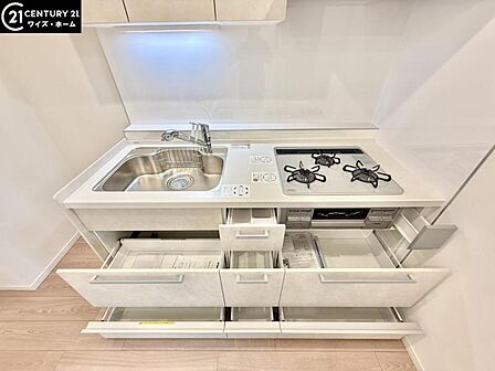 【キッチン】 効率的にお料理できる便利な3口コンロをはじめとしフライパンなど大きな料理道具をきれいに収納できる機能的な大型収納スペースが備わった快適なキッチンスペース