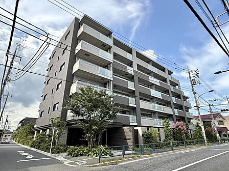 【外観】青空と手入れの行き届いた緑豊かな生垣が魅力。管理体制の良さが伺える落ち着いた外観。