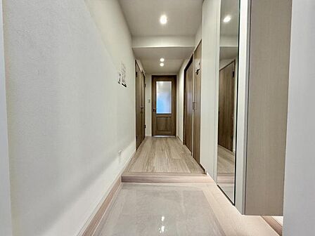 【玄関】木目とホワイトカラーが調和した温かみのある玄関。ナチュラルな素材感が上質で心地よい住まいの第一印象を演出します。