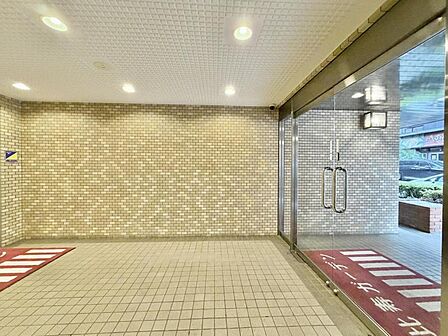 【エントランス】ガラス越しに注ぐ柔らかな光。居住者を優しく出迎えてくれる。