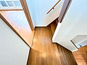 【リフォーム済】1階ホールの写真です。フロアは重ね張りを行い、クロス張替えと照明の交換を行いました。