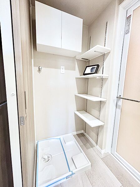収納棚つきの洗濯機置き場。洗濯洗剤などの置き場に便利です!