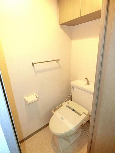 洗浄便座付トイレ。トイレ用品の整理整頓に便利な吊戸棚があります。
