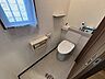 トイレ：窓から自然光が差し込む明るいトイレ空間。収納棚も備え付けられ、機能性も兼ね備えています。快適なプライベート空間で日々の疲れを癒しませんか。
