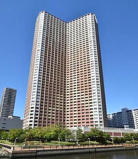 V字型のフォルムが特徴的な高層タワーマンションで、ブラウンとホワイトを基調とした外観デザインとなっており、敷地周りには植栽などの緑地や水辺に沿った遊歩道が整備されています。