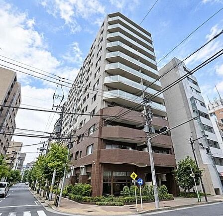 下階部分には深みのあるブラウンのタイル、上階部分には明るいグレーの外壁とガラス手すりのバルコニーを採用した、角地に位置する重厚感と清潔感を兼ね備えたデザインのマンションです。