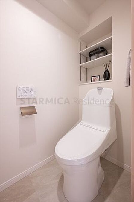 白を基調にした清潔感のあるトイレには、便利な棚板を設置