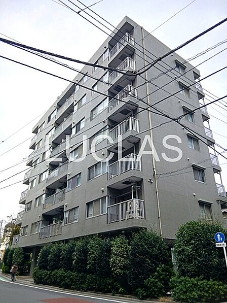落ち着いた色合いの外観が魅力のマンション。植栽が建物を彩り、穏やかな住環境を演出します。