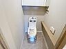 トイレ：吊戸棚とカウンター棚を備えた、すっきり清潔感のある快適なトイレ空間です。