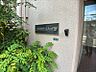 外観：「上前津サンハイツ」の看板と、建物の壁面です。緑豊かな植栽が、落ち着いた雰囲気を演出しています。