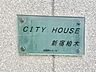 エントランス：存在感のあるマンション名プレートは、落ち着きのある温かな空間を演出します。家族が笑顔になれる住まいへ。