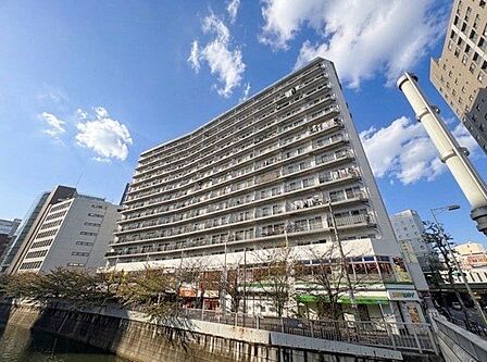 街並みに自然と馴染む色を基調とした外観は、温かみのある色合いが全体を包み、やさしい雰囲気を感じます。(空の加工を生成AIで行っています)