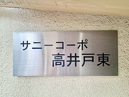 存在感のあるマンション名プレートは、落ち着きのある温かな空間を演出します。家族が笑顔になれる住まいへ。