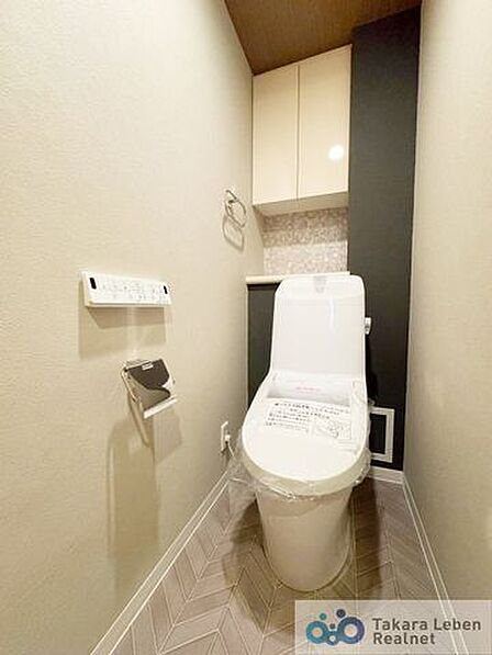 ウォシュレット機能付きのトイレは壁掛けリモコンの上位グレードを採用。便座がスッキリした印象となり、限られた空間を広く見せる効果があります。