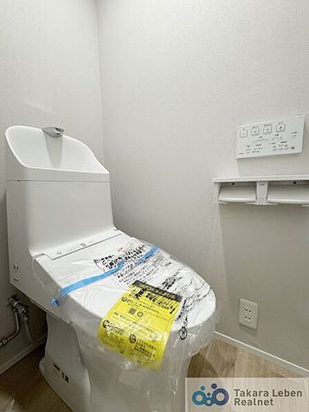 ウォシュレット機能付きのトイレは壁掛けリモコンの上位グレードを採用。便座がスッキリした印象となり、限られた空間を広く見せる効果があります。