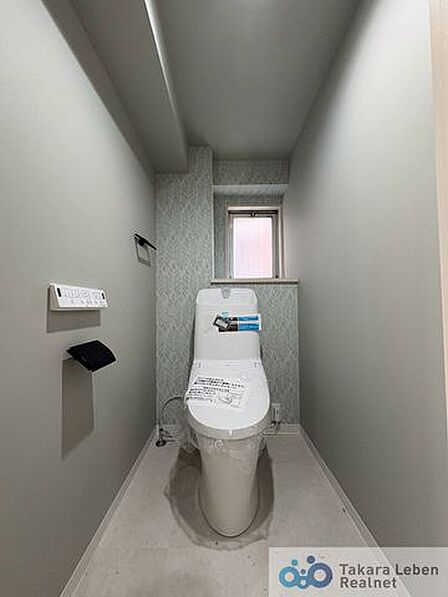 ウォシュレット機能付きのトイレは壁掛けリモコンの上位グレードを採用。便座がスッキリした印象となり、限られた空間を広く見せる効果があります。