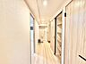 室内：木目の美しい建具と柔らかな色合いが調和する、すっきりと洗練された廊下空間。
