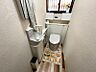 トイレ：小窓から光が差し込む明るいトイレ空間。上部収納棚と手洗いカウンター下にも収納スペースがあり、すっきり片付きます。