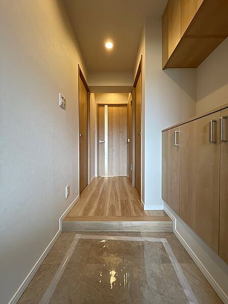 明るい木目調の建具と収納が統一感を生み出す玄関。日々の外出が気持ちよくなる、すっきりとした空間です。