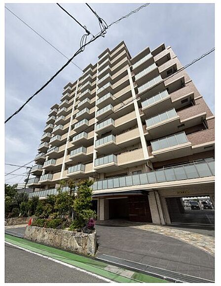 都市の利便性と住まいの快適さを追求したマンション。明るいバルコニーが配され、開放的な暮らしを演出します。建物前面には植栽が施され、落ち着いた住環境です。