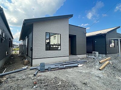 外観：現代的なデザインの外観が目を引く新築住宅。洗練されたツートーンカラーで、新しい生活が始まる予感を感じさせます。完成が待ち遠しいですね。