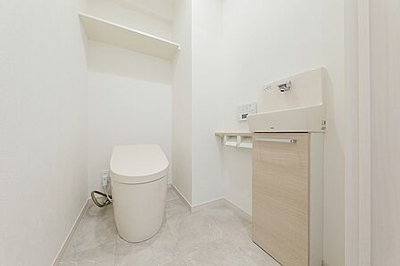 清潔感あふれるトイレは、訪れる人に心地よい印象を与えます。独立型手洗いカウンターと収納で、機能性と美しさを両立。毎日を快適に過ごすための空間です。