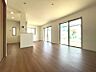 リビング/ダイニング：南向きの窓から光が差し込む、明るいリビング。木目調のフローリングが空間に温かみを添えます。