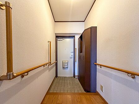 左右に手すりを備えた玄関。シューズ収納もあり、家族の靴をすっきり整理できます。
