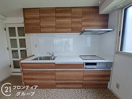 上質な木目調のデザインが高級感を演出するキッチンです。広いワークトップは料理の時間をより優雅に彩ります。最新の設備が整っており、日々の家事もスマートにこなせる機能美が魅力的な空間です