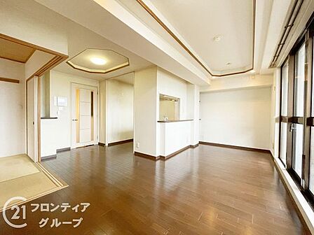 大きな窓から差し込む陽光が室内を明るく彩る、開放感に満ちたリビングルームです。上質な素材感のフローリングが心地よく、家族が自然と集まりたくなるような温かみのある住空間が広がっています