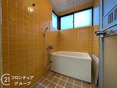 柔らかな色調のタイルに包まれた、一日の疲れを優しく解きほぐす寛ぎのバスルームです。自然光が差し込む窓が設置されており、開放感溢れる空間でリラックスしたバスタイムを心ゆくまでお楽しみいただけます
