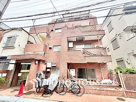 赤茶色のタイル貼りが特徴的な、レトロな雰囲気の低層マンションです。