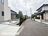 外観：前面道路沿いには黒いフェンスと側溝が整備されています。歩行者にも配慮された安全な道路環境です。