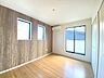 寝室：バルコニーに面した温もり溢れる明るいお部屋。 寛ぎの時間を紡ぎだす主寝室は、大型ベッドを置いても余裕の広さを確保しています。