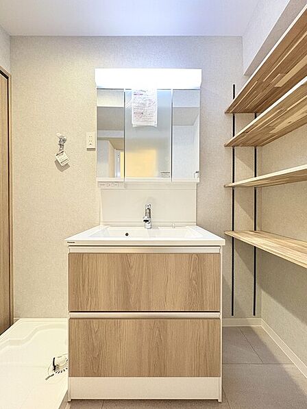 洗面室内にも可動棚収納造作 洗面化粧台は収納しやすいスライド式