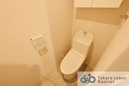 ウォシュレット機能付きのトイレは壁掛けリモコンの上位グレードを採用。便座がスッキリした印象となり、限られた空間を広く見せる効果があります。