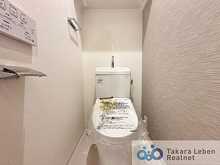 ウォシュレット機能付きのトイレは壁掛けリモコンの上位グレードを採用。便座がスッキリした印象となり、限られた空間を広く見せる効果があります。