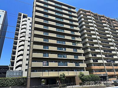 外観：青空に映える大規模マンション。開放的な暮らしを叶える広々バルコニーで、日々の疲れを癒しませんか。