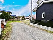 広々とした前面道路に面し、車の出し入れがしやすい現地外観。ゆとりある駐車スペースと開放感のある立地が魅力で、毎日の暮らしに快適さと安心をもたらすマイホームです。