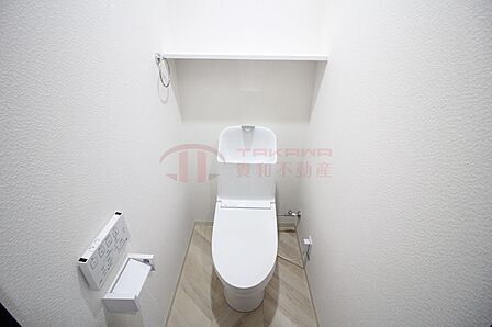 上部に便利な棚を備えた温水洗浄便座付きの快適なトイレ空間