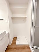 洗濯機置場。上段に収納棚があり、洗剤や消耗品などを収納できます