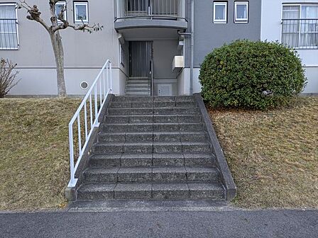 丁寧に手入れされた植栽が優しく出迎えるエントランスは、住まう人の品格を感じさせます。手すり付きの階段が設けられた安心の設計で、毎日を健やかに支える細やかな配慮が随所に散りばめられています