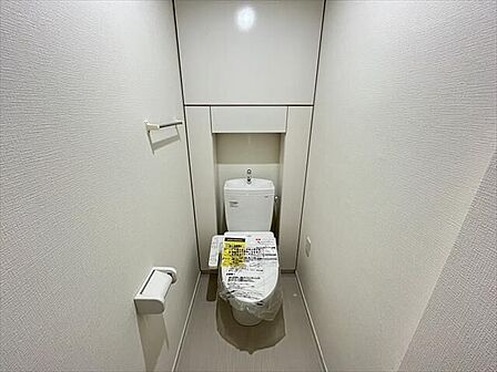 白がキレイなトイレ♪後方には収納棚が付いています!トイレットペーパーなどのストックも置いておけますね。